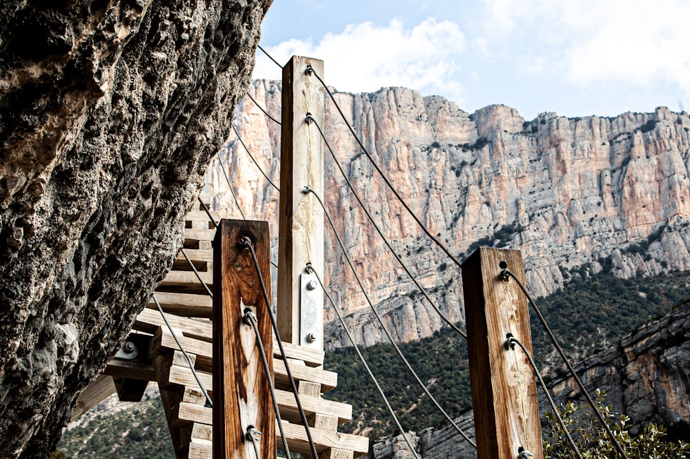 brown wooden ladder on brown rock formation during daytime