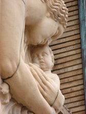 Close-up of a marble sculpture representing gentle motherhood and protection.