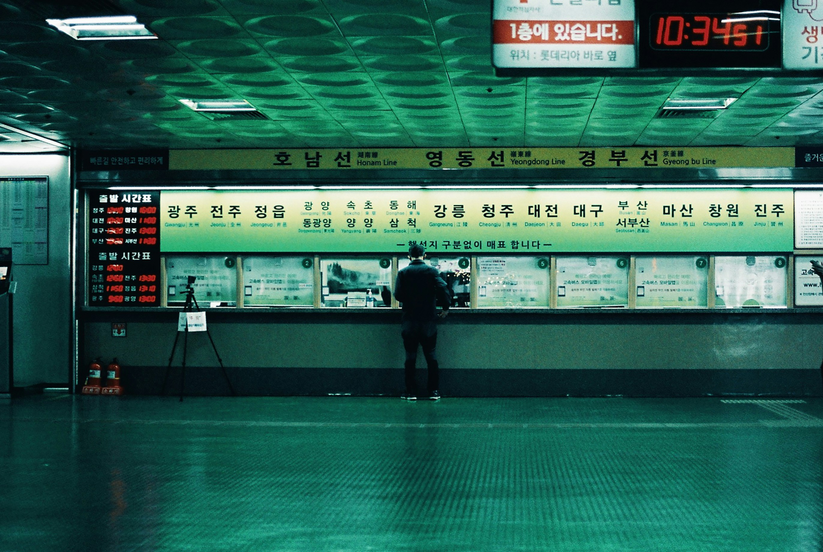 man in black jacket walking on green floor