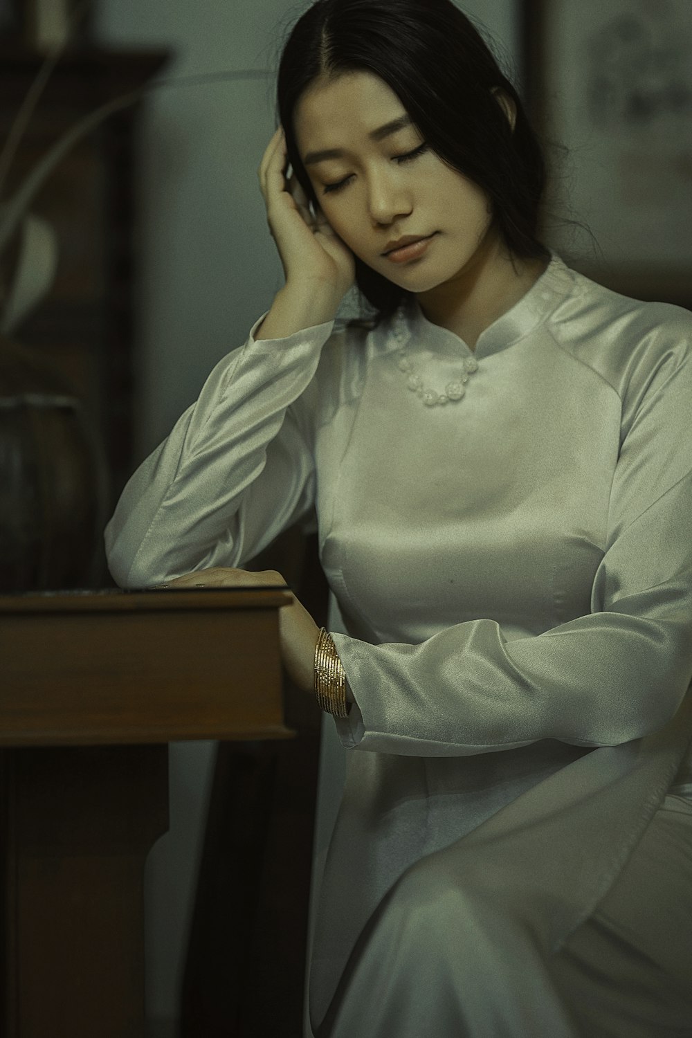 woman in white long sleeve shirt holding her face