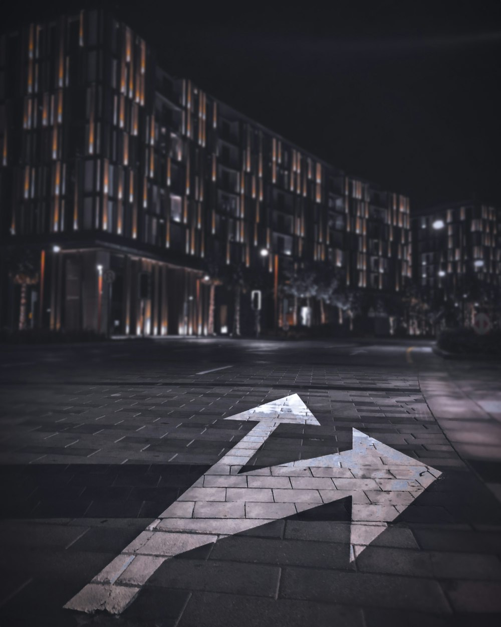 grey and white star print concrete road in between high rise buildings during nighttime