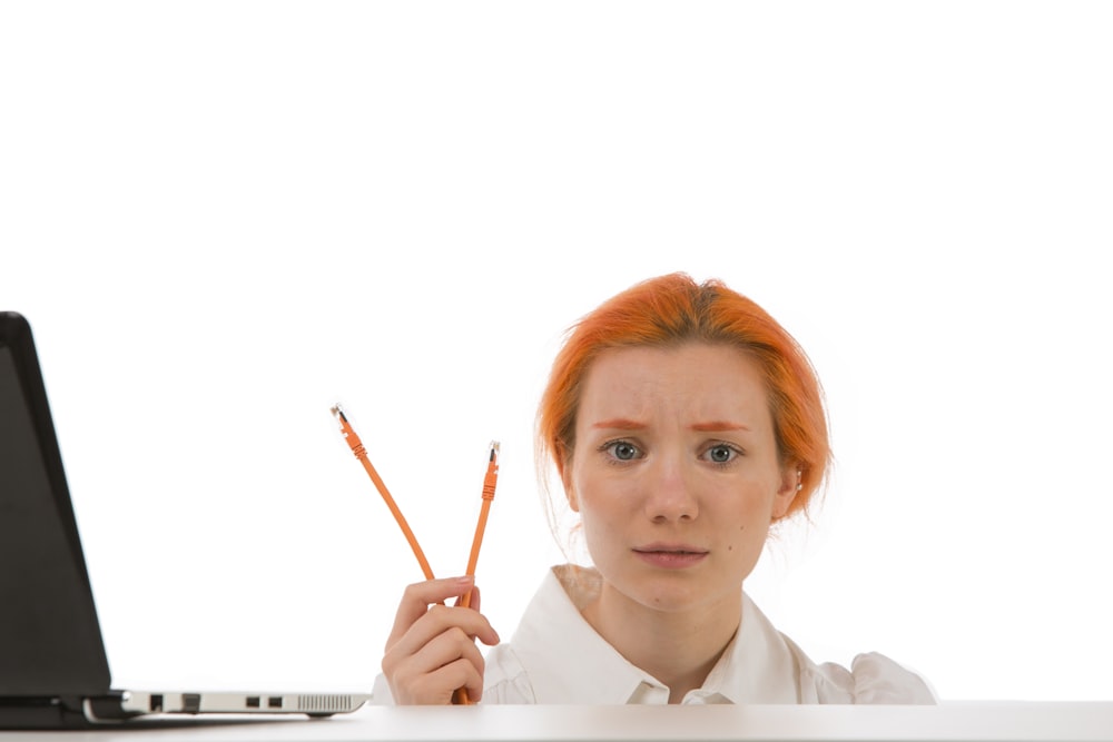 woman in white collared shirt holding pen