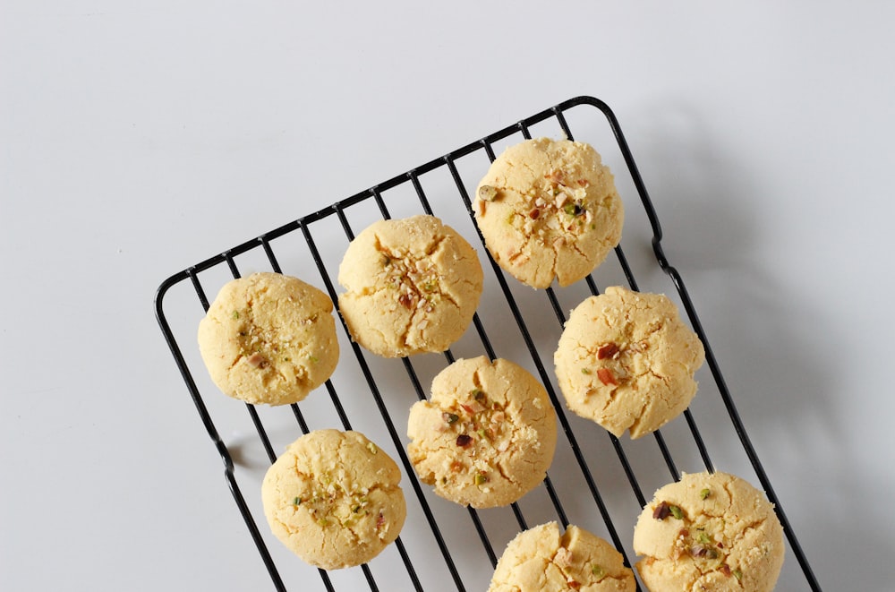 white and yellow flower shaped pastries on black metal rack