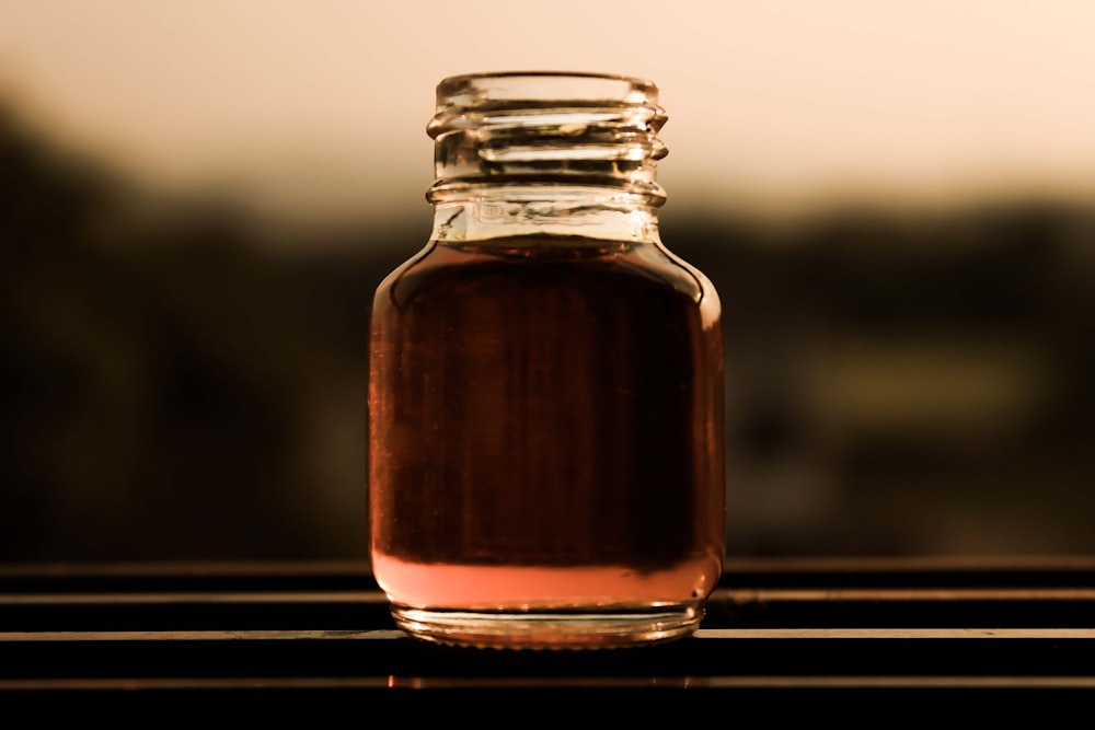 clear glass jar with brown liquid