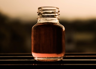 clear glass jar with brown liquid