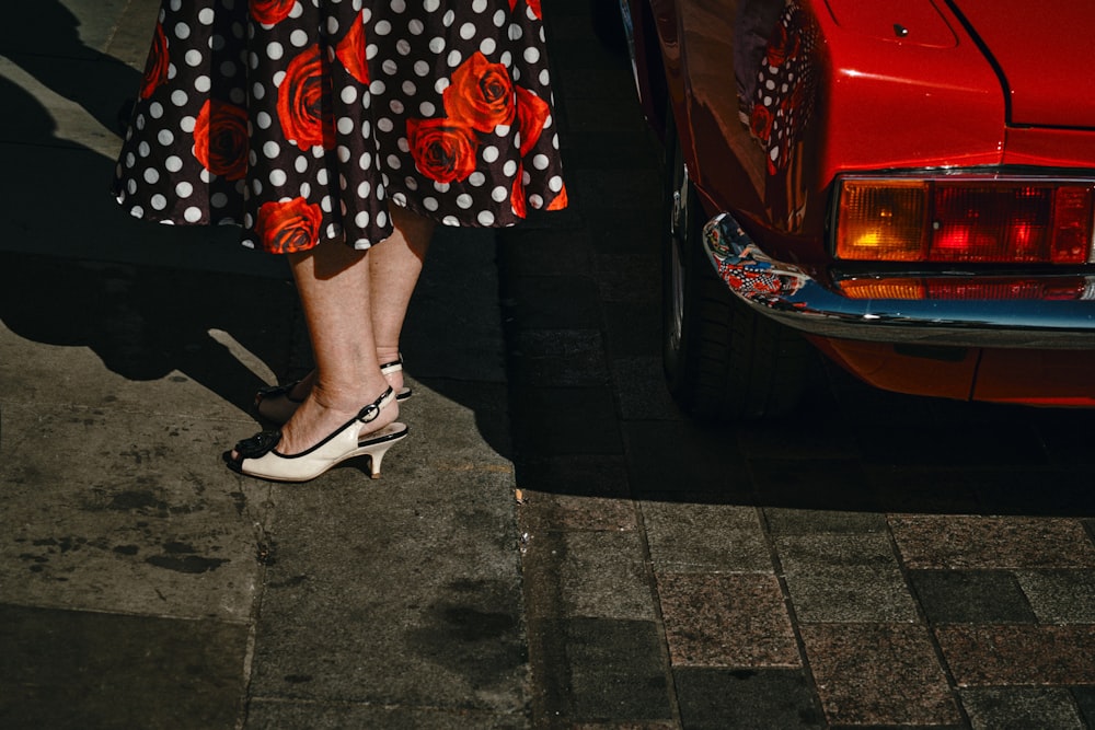 woman in black white and red polka dot skirt and white leather peep toe heeled shoes