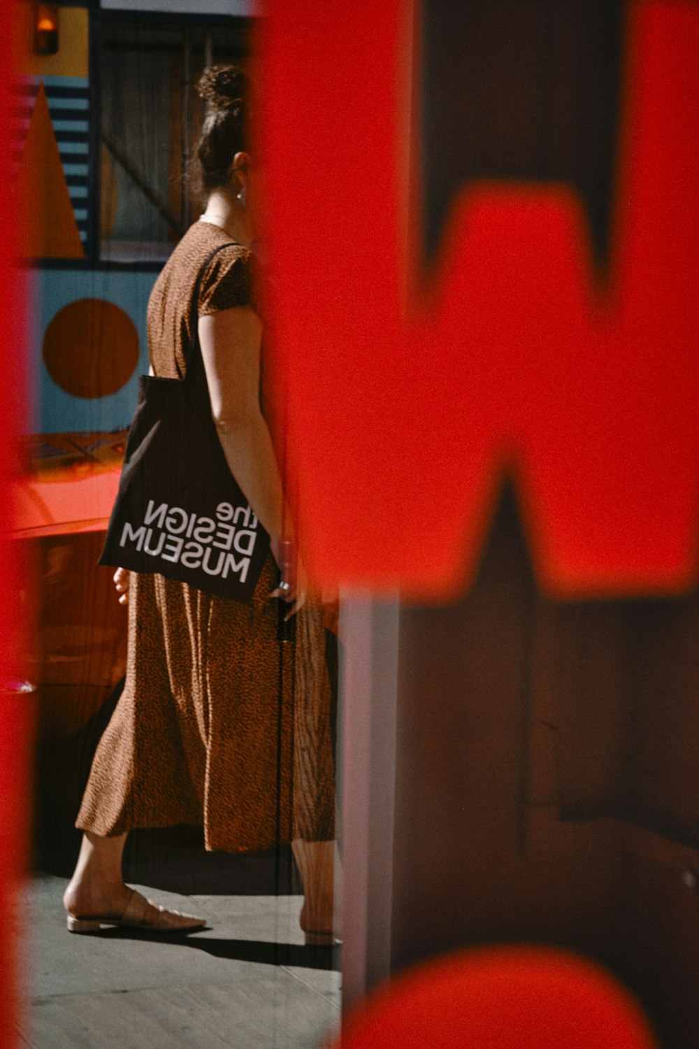 woman in black tank top and brown coat standing