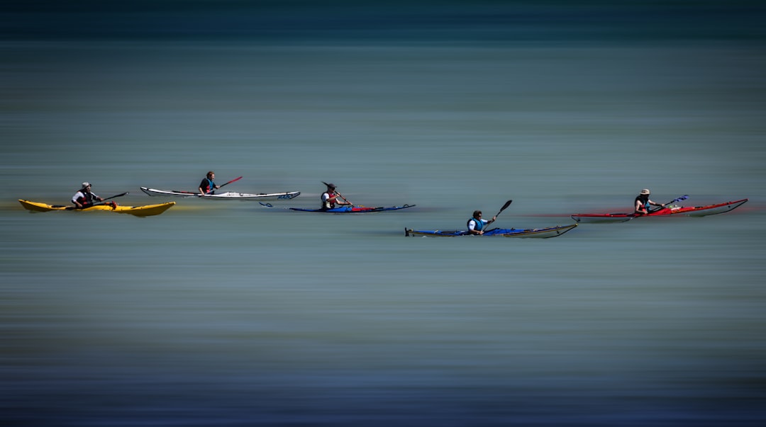 2 person riding on red kayak on sea during daytime