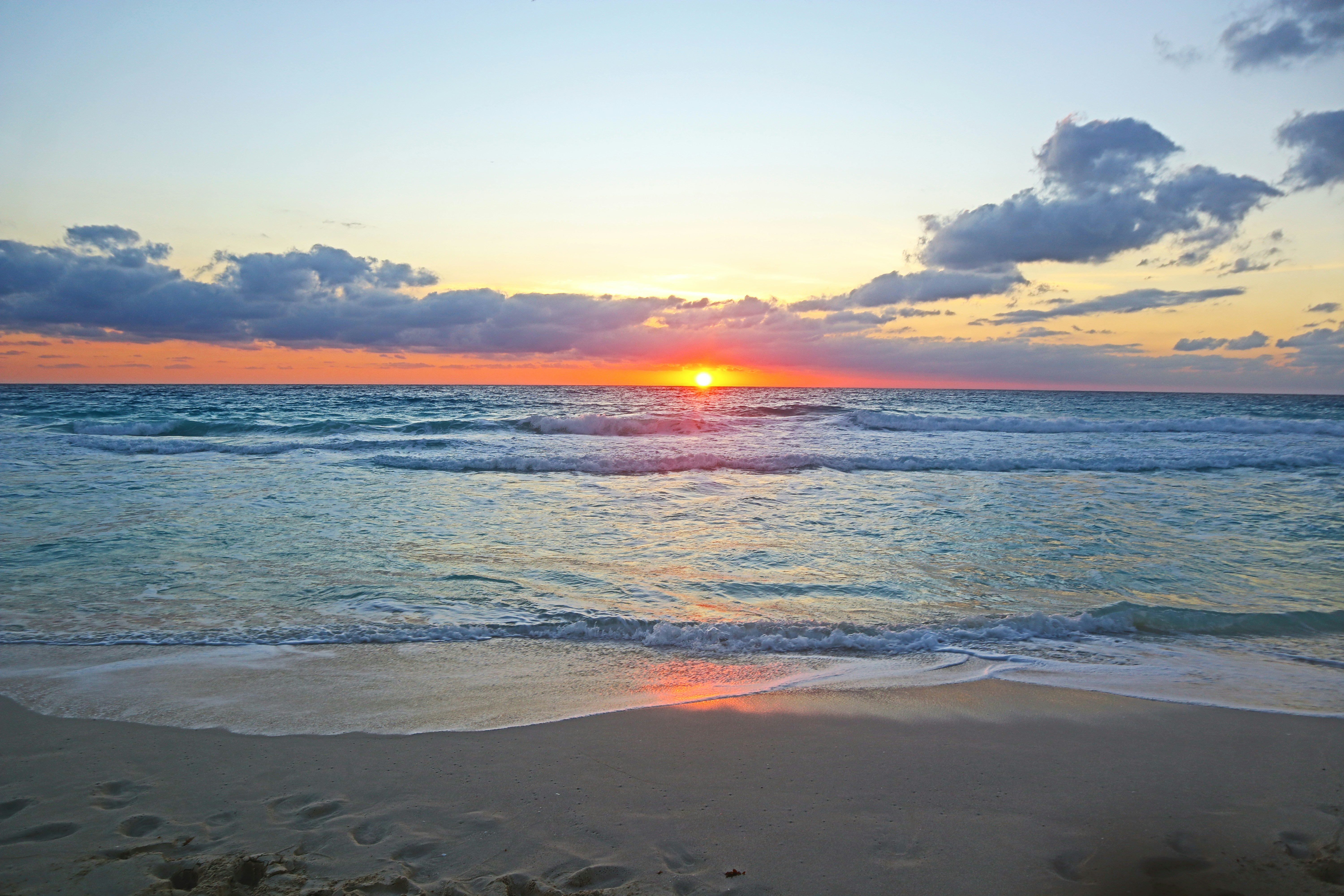 sea waves crashing on shore during sunset