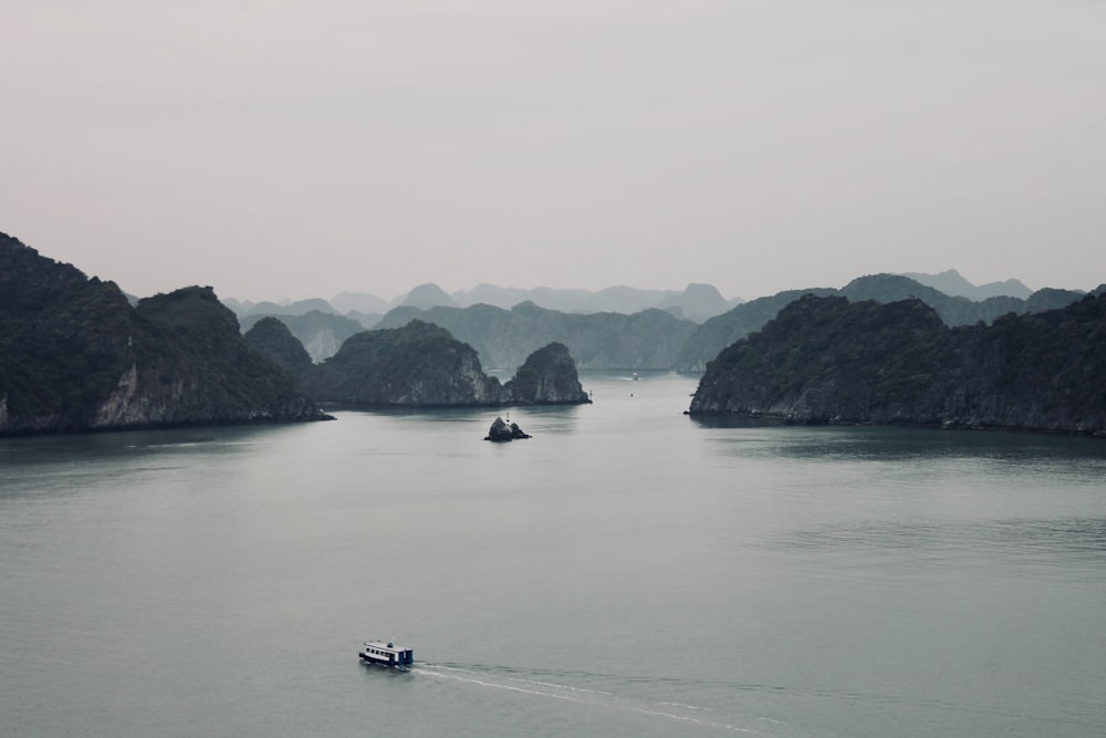 boat on sea near mountain during daytime