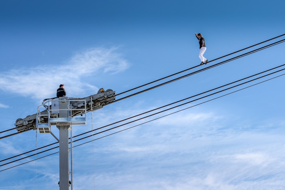 man in black t-shirt and black shorts on gray metal tower during daytime