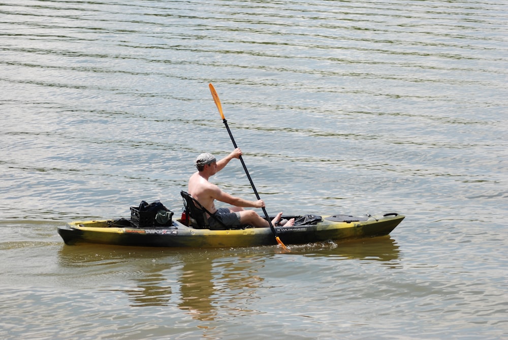 man and woman riding yellow kayak on body of water during daytime