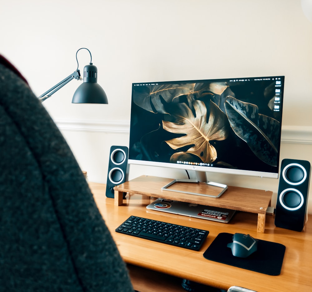 black flat screen computer monitor on brown wooden desk