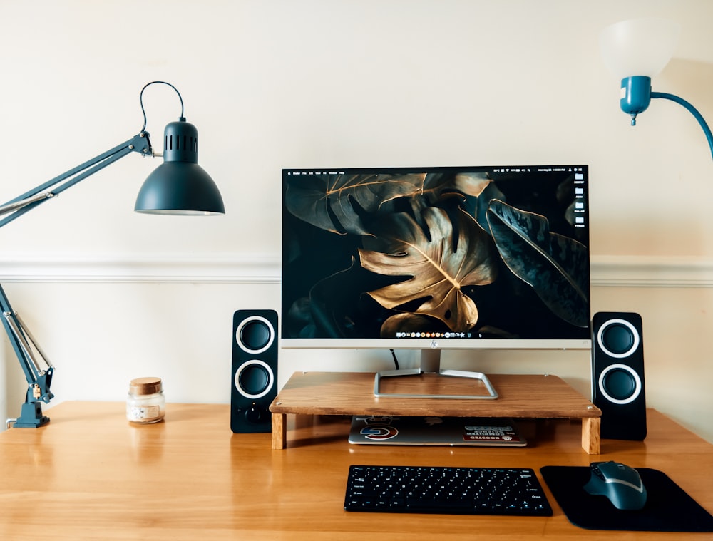 black flat screen computer monitor on brown wooden desk