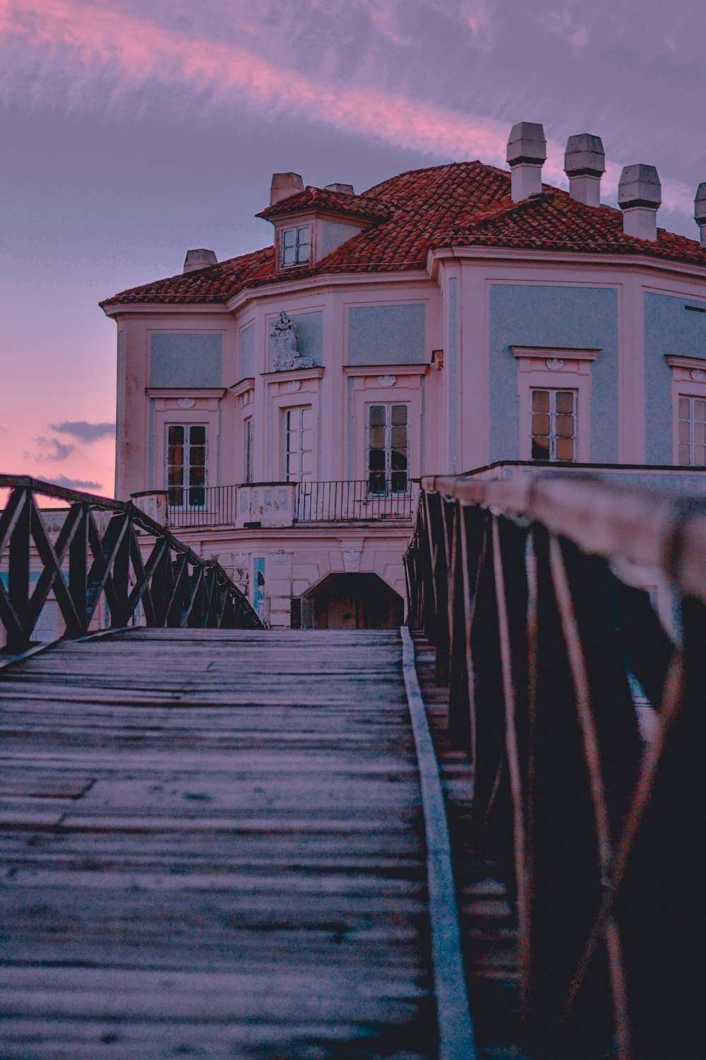 brown wooden bridge over white and brown concrete house during daytime