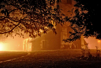 A moody, cinematic shot of the manor's grand entrance bathed in soft golden light at dusk.