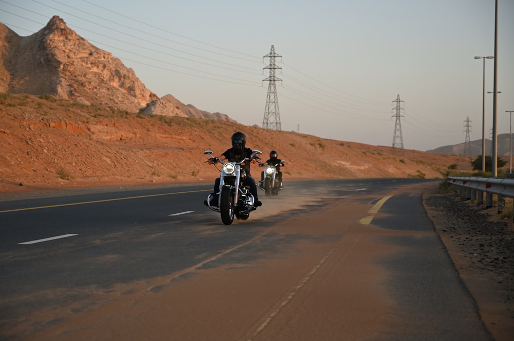 hombre con chaqueta negra montando motocicleta en la carretera durante el día