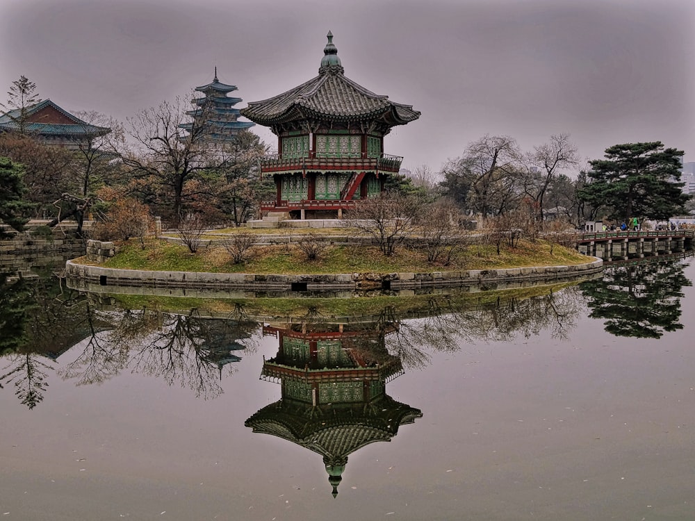 green and brown pagoda temple near lake