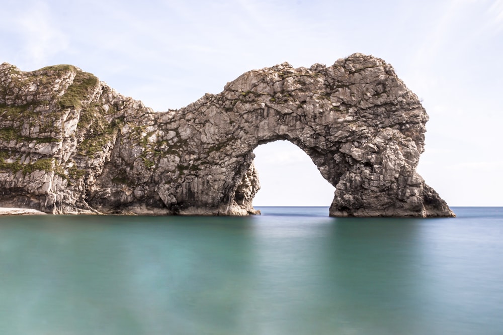 gray rock formation on blue sea under blue sky during daytime