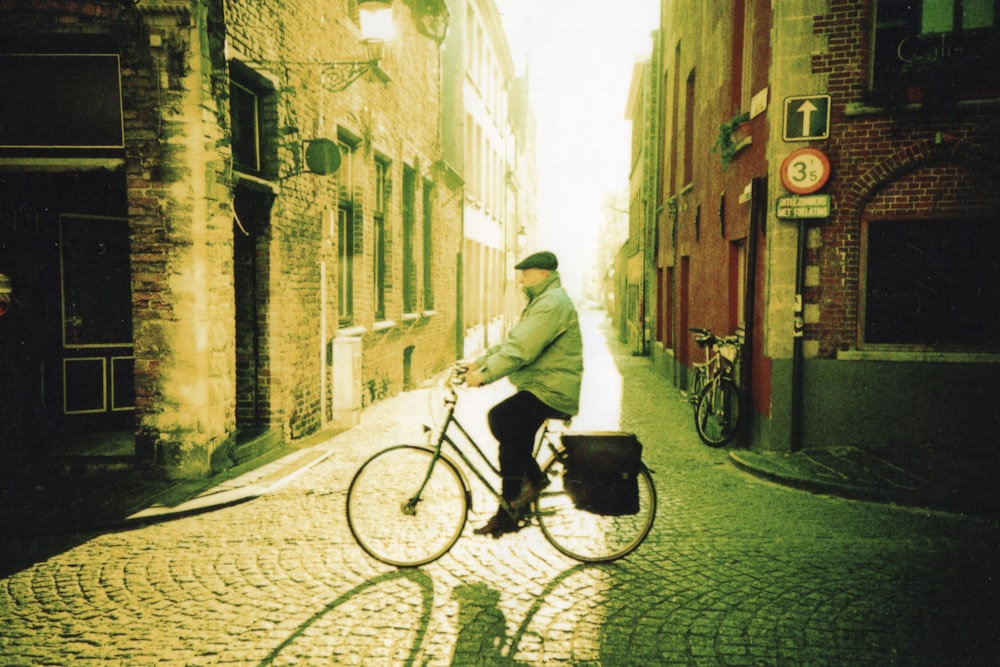 낮 동안 거리에서 자전거를 타고 하얀 까마귀를 입은 남자