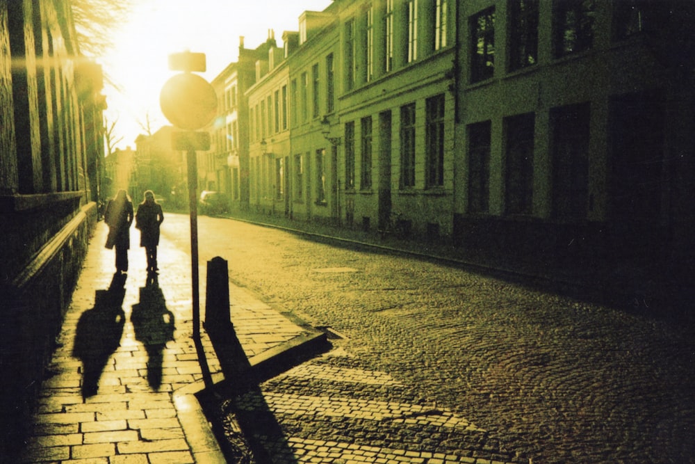 man in black jacket and pants walking on sidewalk during night time