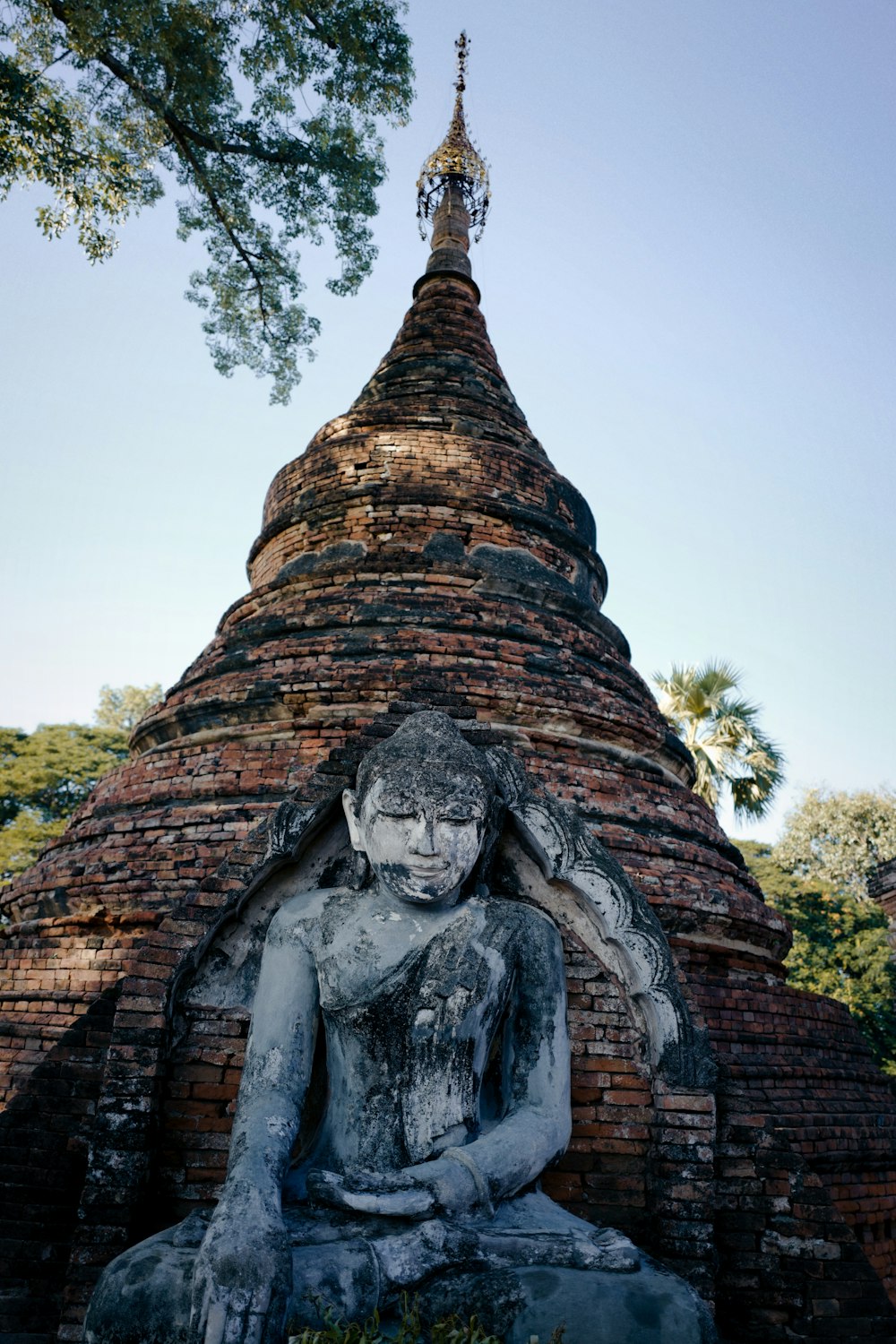 Estatua de hormigón gris en la parte superior del edificio de hormigón marrón y gris