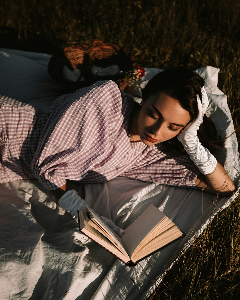 woman in red and white long sleeve shirt lying on brown grass field during daytime