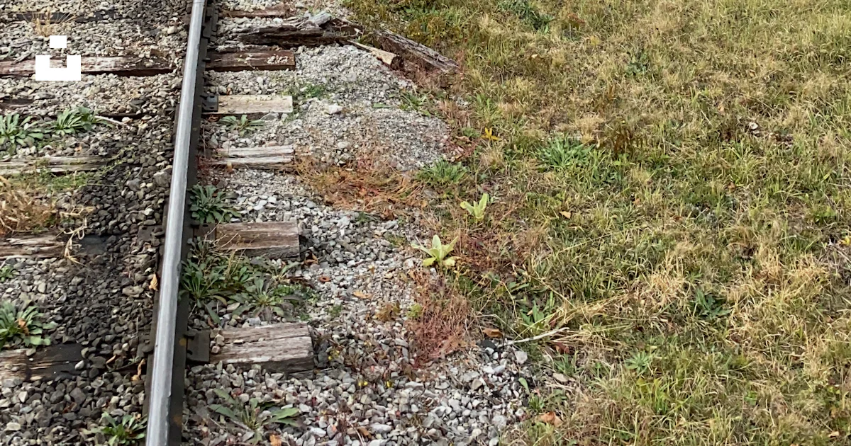 A train track in the middle of a field photo – Free Building Image on ...