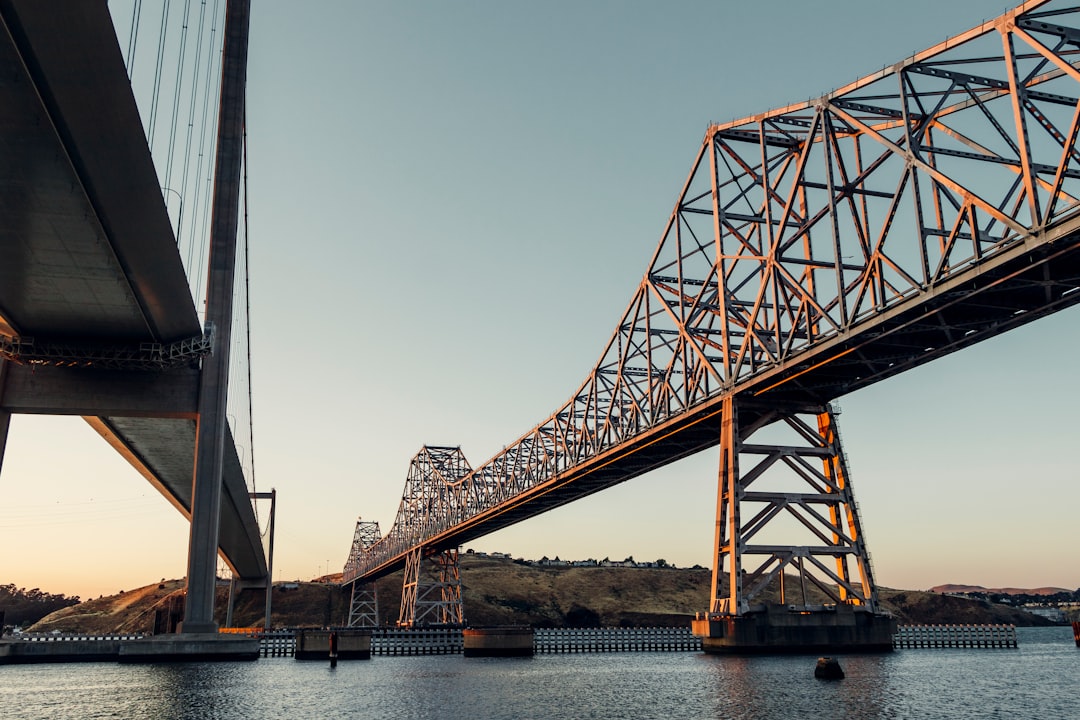 gray steel bridge over body of water during daytime