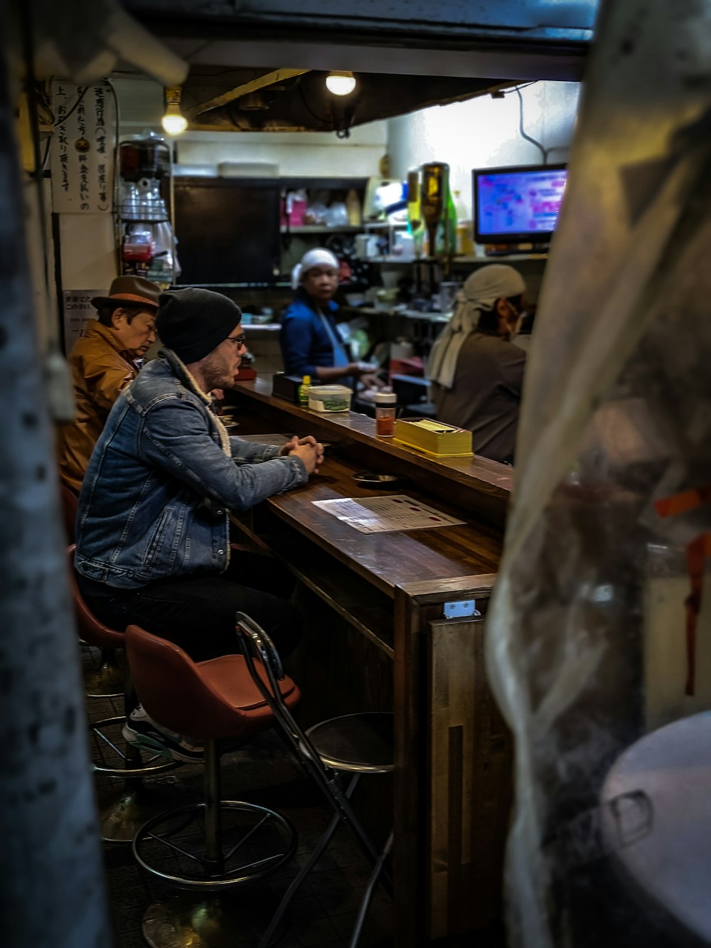 man in black leather jacket sitting on chair