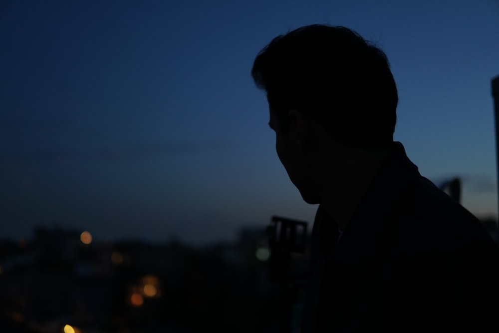 man in black suit jacket looking at the sun