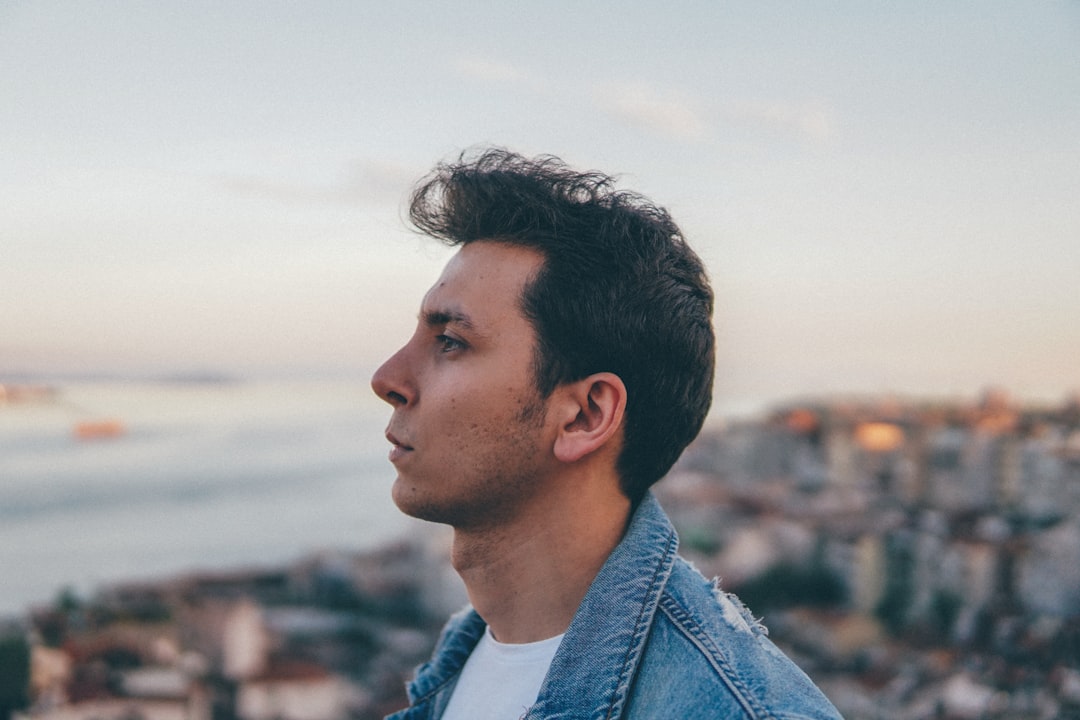 man in blue denim jacket looking at the sky during daytime