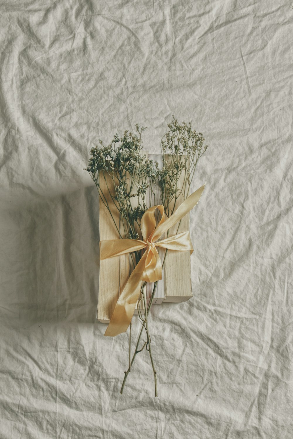 white and green flower bouquet on white textile