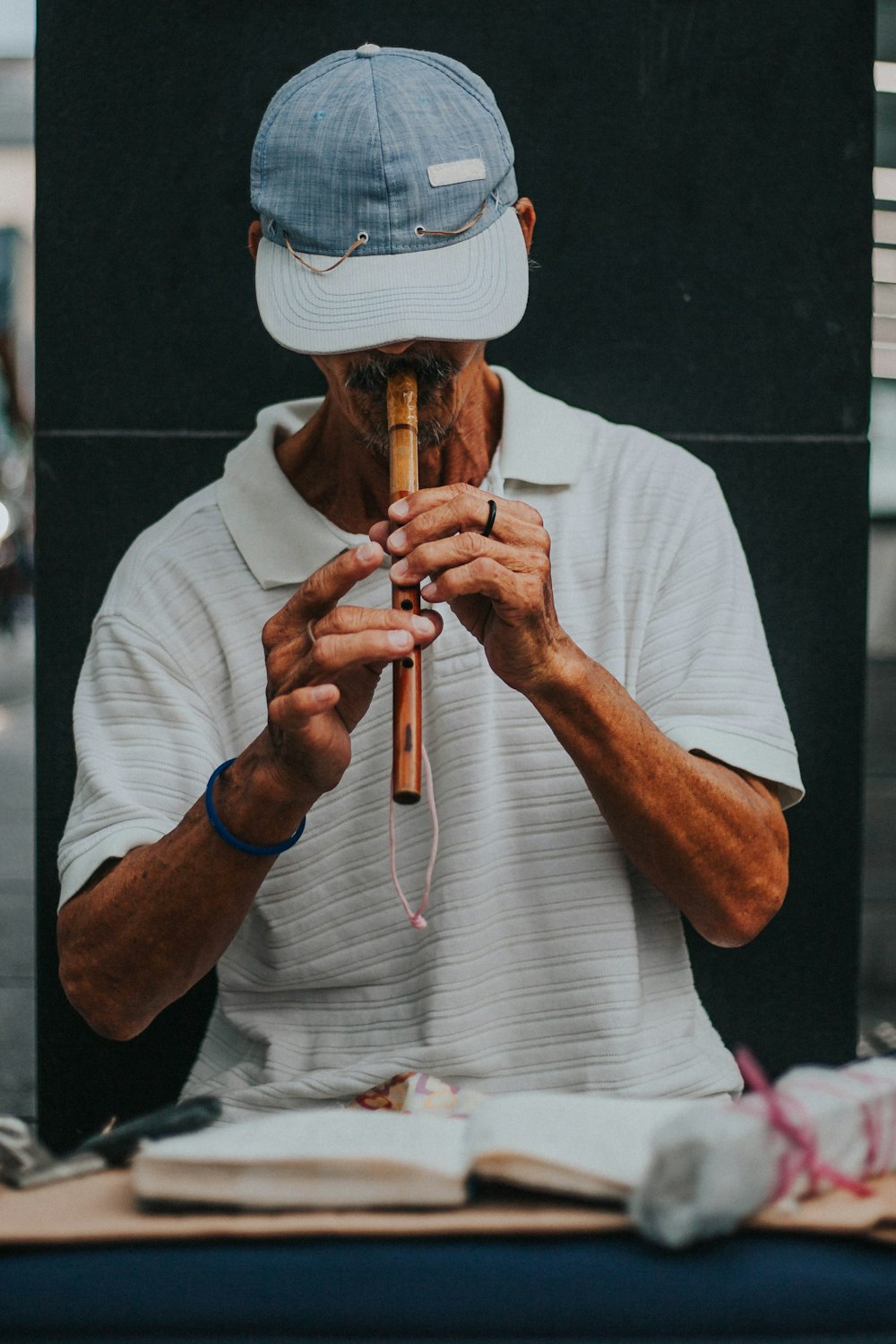 man in gray crew neck shirt wearing brown cowboy hat playing flute