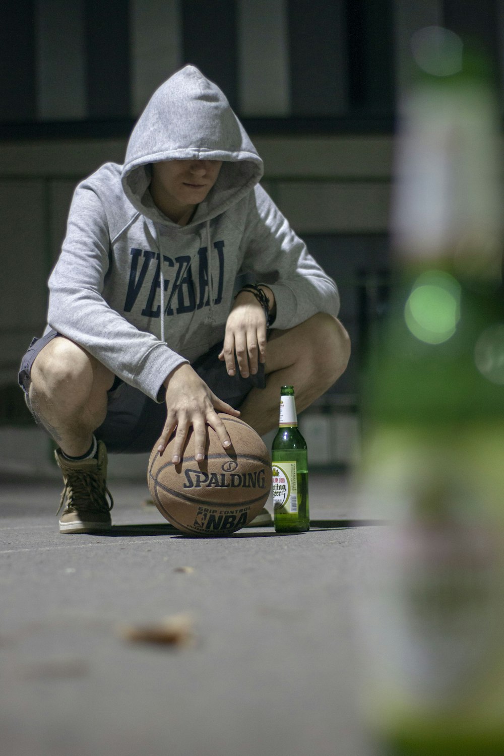 man in gray hoodie holding brown basketball