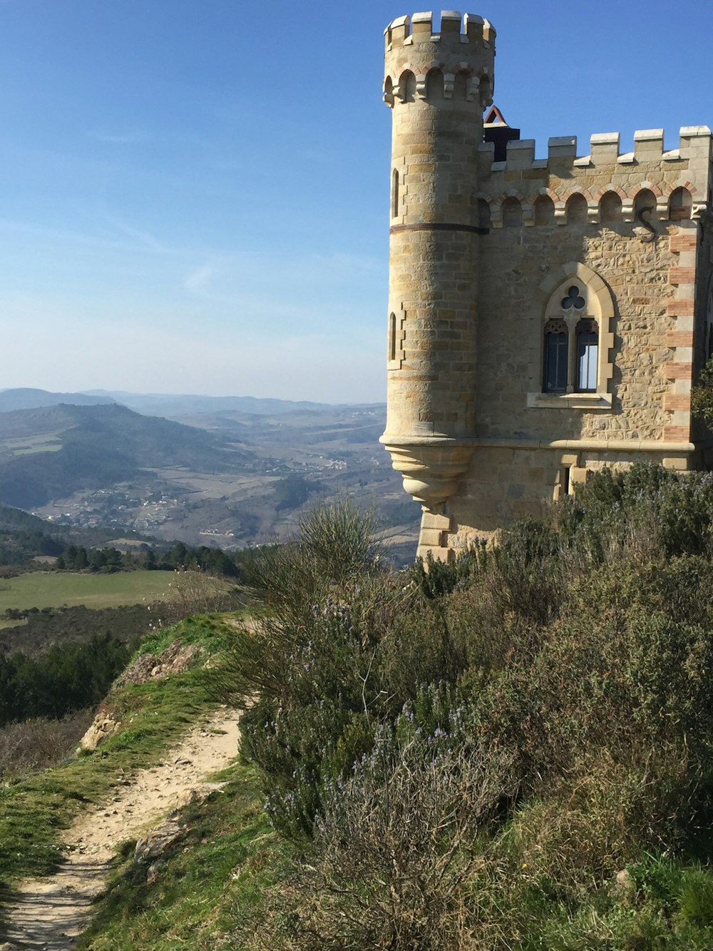 a stone castle on a hill overlooking a valley