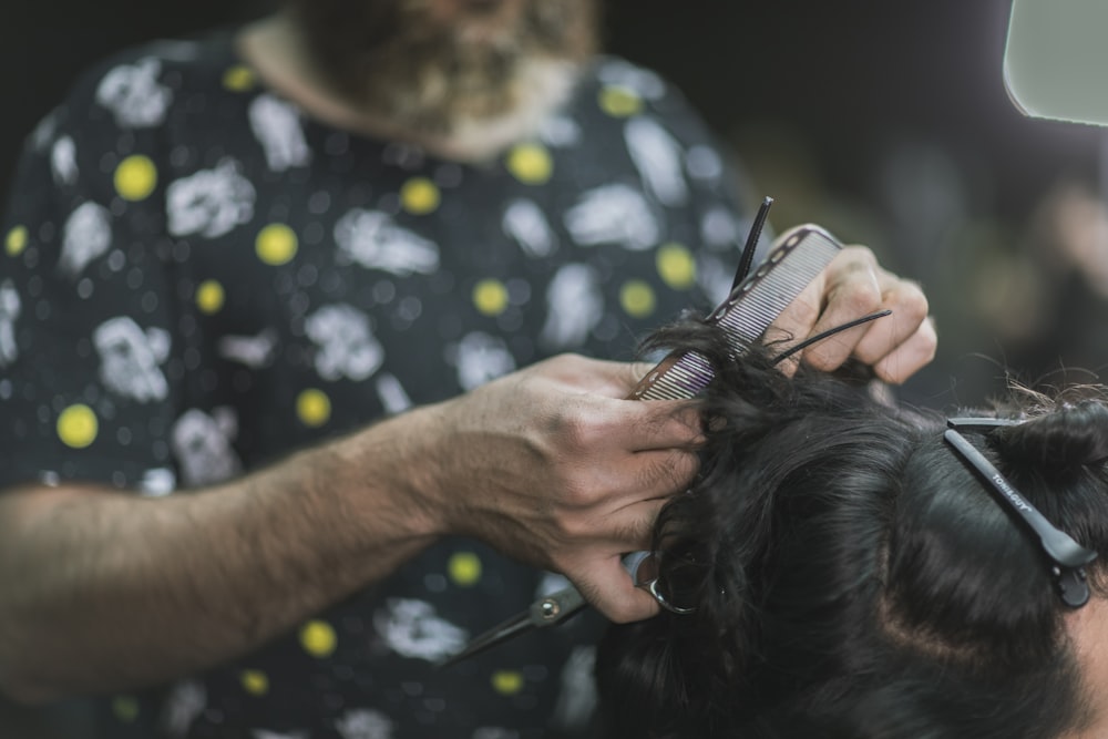 Person in schwarz-gelbem Hemd mit schwarzem und braunem langhaarigem Hund