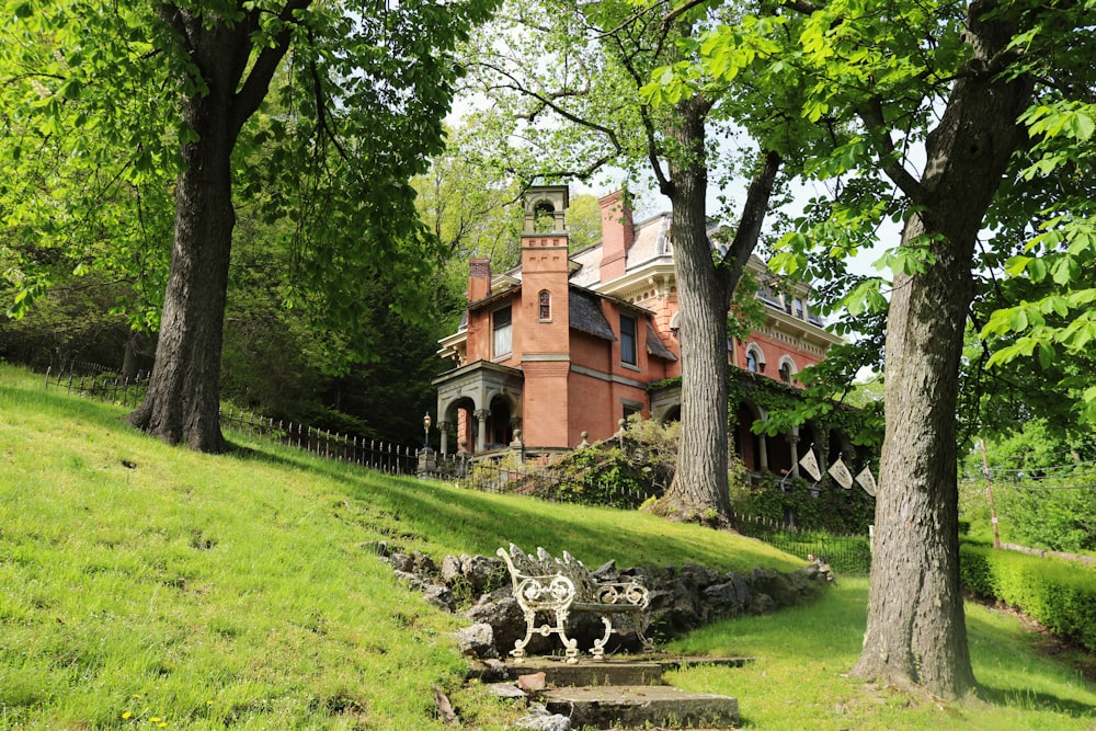 brown concrete house near green grass field during daytime