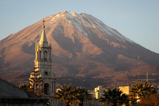 white and brown concrete building near green trees and mountain during daytime in Arequipa Peru