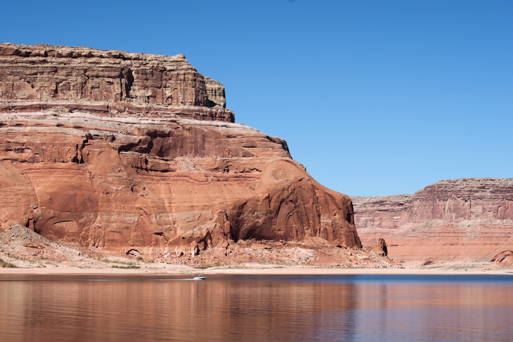 brown rock formation near body of water during daytime