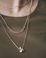Delicate layered necklaces arranged on a light fabric, highlighting their fine details.