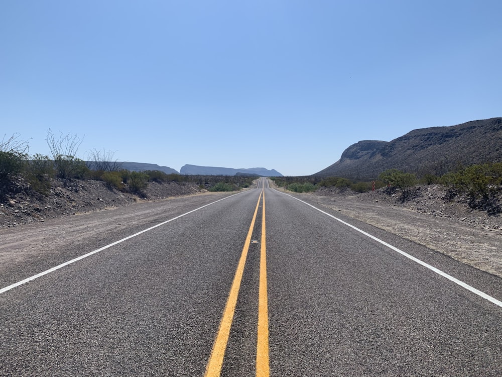 gray asphalt road under blue sky during daytime