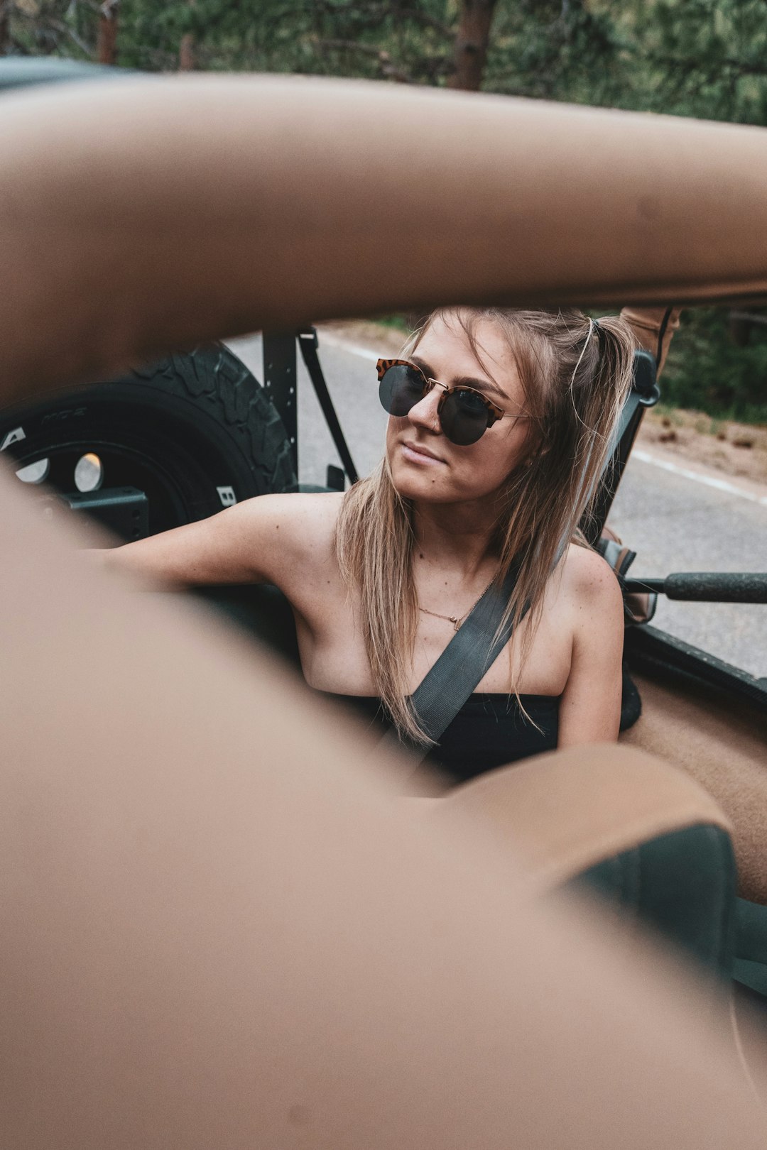 woman in black tank top wearing black sunglasses sitting on car seat