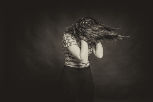 woman in black and white striped long sleeve shirt covering her face with hair