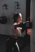A mother practicing Krav Maga moves in a bright, welcoming studio.
