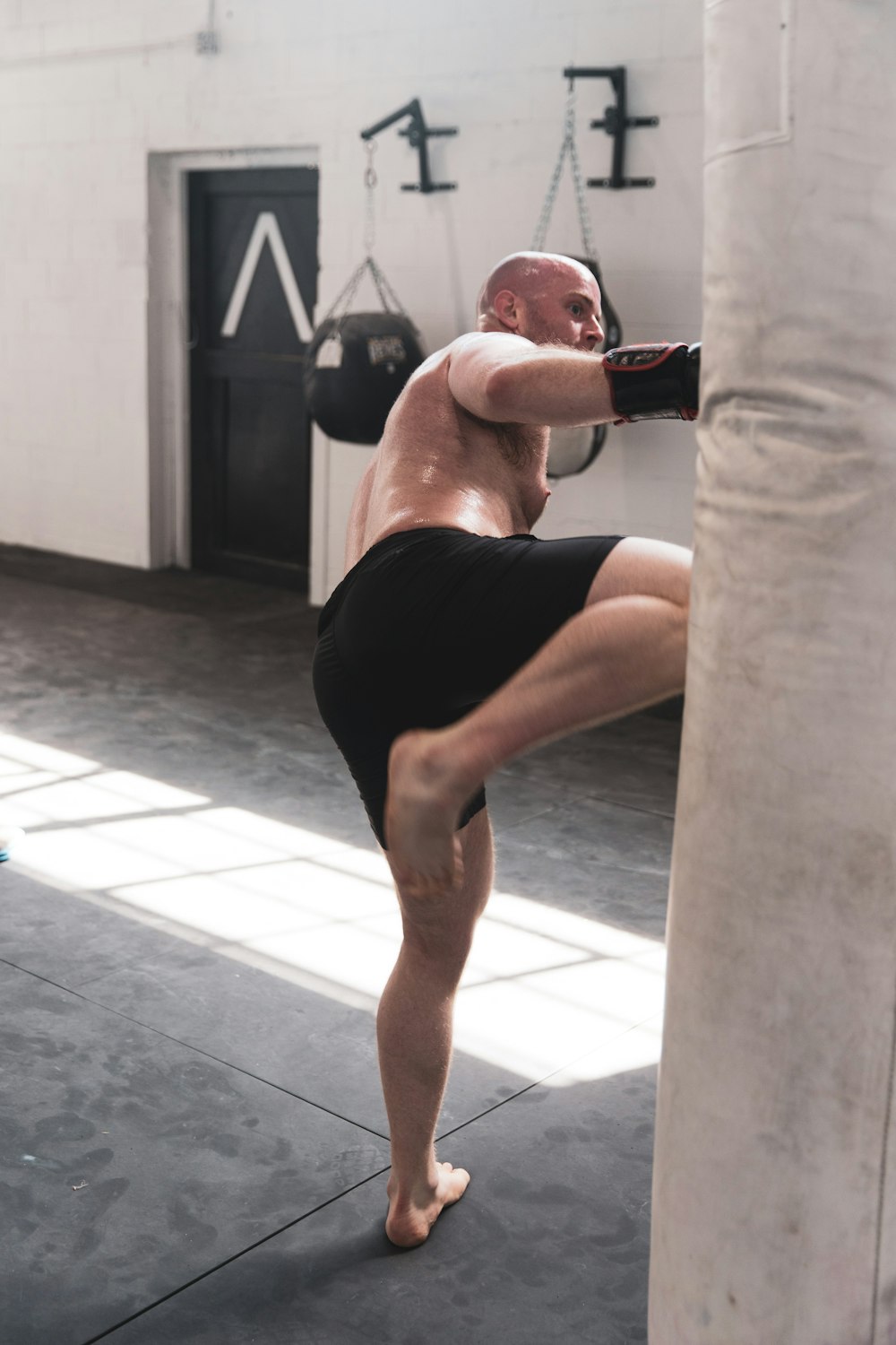 Hombre con pantalones cortos negros y guantes de boxeo rojos