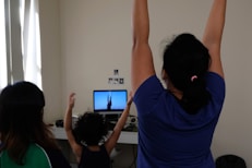 woman in blue t-shirt raising her hands