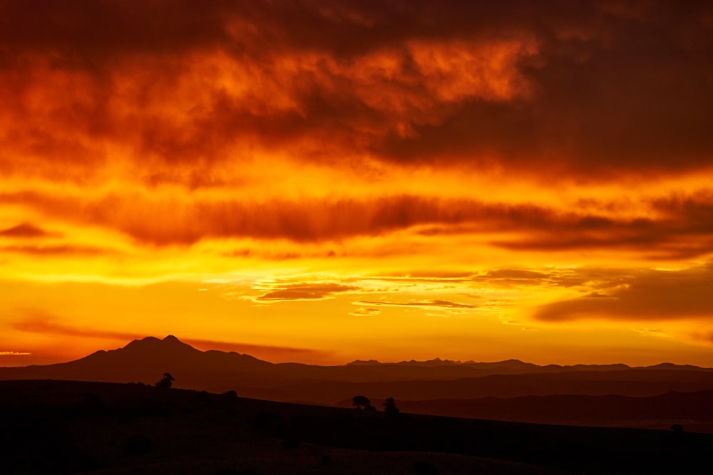 silhouette of people on mountain during sunset