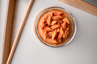 Close-up of a colorful bowl filled with crunchy salted snacks on a rustic wooden table.