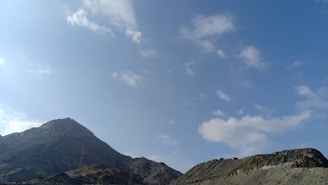 A scenic landscape photo featuring mountains and a clear blue sky.